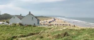 a house on the side of a beach with people at Creative Art Cabin, Causeway Coast, beach 10 mins in Articlave