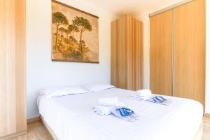 - une chambre avec un lit blanc et des serviettes dans l'établissement SELECT'soHOME - Splendide Mazet avec vue mer à La Fossette - SOLE&MARE, au Lavandou
