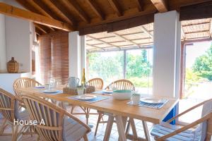 a dining room with a wooden table and chairs at Casa Oleandra in Melides