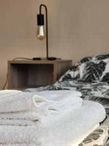 una pila de toallas sentadas encima de una cama en Moderno apartamento con vista a la Cordillera en Luján de Cuyo
