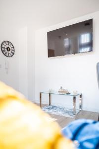 ein Wohnzimmer mit einem Tisch und einer Uhr an der Wand in der Unterkunft Cozy Retreat near Hollingworth Lake, Milnrow, Rochdale in Rochdale