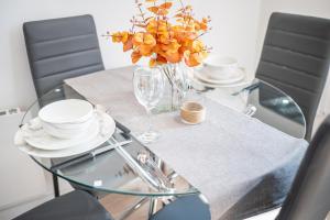 einen Glastisch mit einer Blumenvase darauf in der Unterkunft Cozy Retreat near Hollingworth Lake, Milnrow, Rochdale in Rochdale