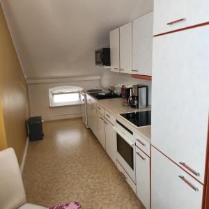 eine Küche mit weißen Schränken und einem weißen Kühlschrank in der Unterkunft Merseburger Straße 402 in Ammendorf
