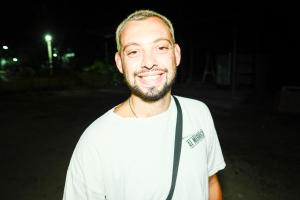 un hombre con una camisa blanca sonriendo por la noche en Escape Divers - The Jungle, en Ko Tao