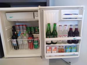 um frigorífico aberto cheio de muitas bebidas em Motel Kalipso em São José