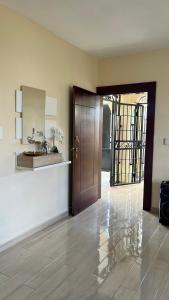 a hallway with a wooden door and a mirror at Casa moderna in Santiago de los Caballeros