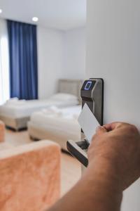 a person holding a piece of paper in a room at Otto Hotel in Ksamil