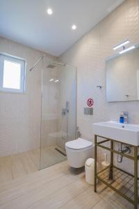 a bathroom with a toilet and a sink and a shower at Otto Hotel in Ksamil +37 photos