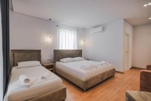 a room with two beds and a couch at Otto Hotel in Ksamil