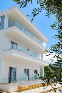 a white house with balconies and trees at Otto Hotel in Ksamil