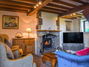 a living room with a fireplace and a tv at Ladycroft House in Hebden