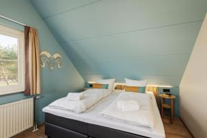 a bedroom with a large bed with blue walls at Center Parcs Eifel Mosel Nürburgring in Gunderath