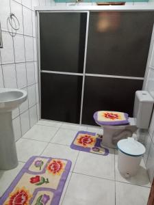 a bathroom with a toilet and two mats on the floor at Pousada Recanto da Villa in Mucugê
