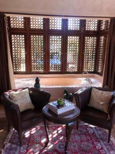 a living room with two leather chairs and a table at Villa Jolyamelkis - golf Marrakech in Marrakesh