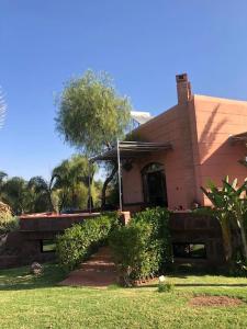 a house with a staircase leading to the front of it at Villa Jolyamelkis - golf Marrakech in Marrakech