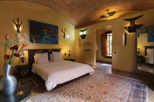 a bedroom with a white bed and a vase with flowers at Villa Jolyamelkis - golf Marrakech in Marrakech
