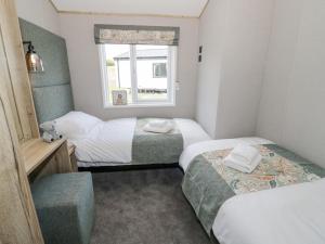 a small room with two beds and a window at Deer Lodge in Worcester