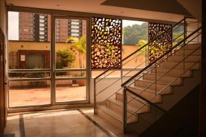 a staircase in a room with a large window at Mi Hotel Sandiego in Medellín