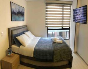 Un dormitorio con una cama con un osito de peluche. en Cómodo Apartamento en Bogotá, Chapinero Central - Theatron, en Bogotá