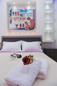 uma rosa sentada em cima de uma cama com toalhas em Anemi Leros Apartments em Panteli