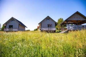 two houses in a field of tall grass at Chatki Dwa Żurawie in Wiżajny