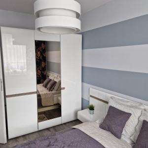 a bedroom with a bed and a mirror at APARTAMENT - PORTA MARE - LEŚNE TARASY - 45B/2 in Dziwnówek