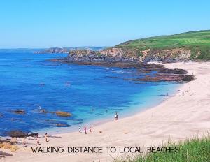 a beach with people swimming in the water at Seaview House in Thurlestone