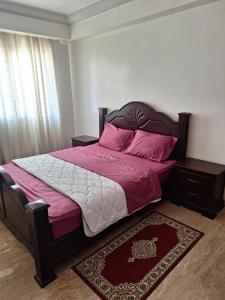 een slaapkamer met een bed met roze lakens en roze kussens bij apartment 2 bedrooms in hassan in Rabat