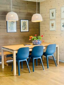 a dining room with a wooden table and blue chairs at Ruim en licht familiehuis No 21 in Föllinge