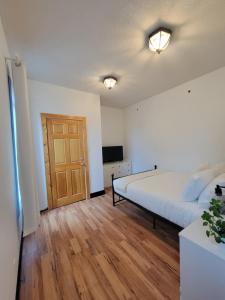 a bedroom with a bed and a wooden floor at Stone House Kenora in Kenora