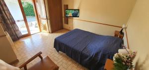a bedroom with a blue bed and a television at CAMAT T1 de plain pied à la campagne in Cazaubon