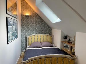 1 dormitorio con 1 cama grande en el ático en Petit gîte d’arrière-cour au pied du Château, en Combourg