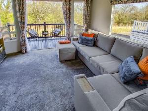 Long View Lodge في Felton: غرفة معيشة مع أريكة وشرفة