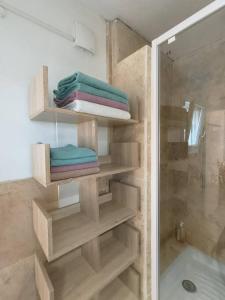 a bathroom with a shower with towels and a toilet at L'Escala Arles Centre in Arles
