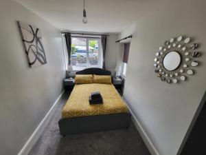 a small room with a bed and a mirror at Courtyard Cottage in Cartmel