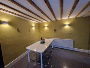 a dining room with a white table and chairs at Courtyard Cottage in Cartmel