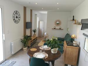 uma sala de estar com uma mesa de madeira e cadeiras em Tiny House moderne et son jardin privé - 5mn Roanne 