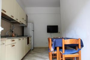 a kitchen with a table and chairs and a tv at Stella Marina in Celle Ligure