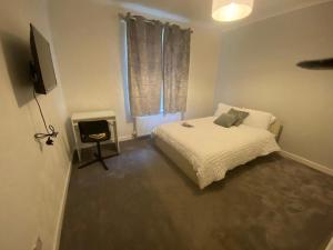 a small bedroom with a bed and a television at Glasgow excellent lodging home in Glasgow