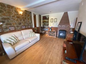 Una sala de estar con un sofá y una chimenea. en Villa Paraes, en Nava
