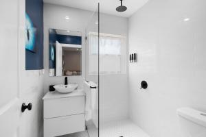 uma casa de banho branca com um lavatório e um chuveiro em Cozy Studio Walking Dis From Rj Stadium em Tampa