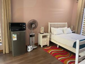 ロードポートにあるSafari Deluxe Rooms - elegant rooms with access to beautiful garden & poolのベッドルーム(ベッド1台、テレビ、ラグ付)