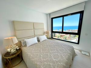 sypialnia z dużym łóżkiem i dużym oknem w obiekcie Luxury 3 Bedroom Penthouse w mieście Fuengirola