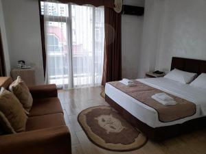um quarto de hotel com uma cama e um sofá em Hotel Royal Palace em Batumi