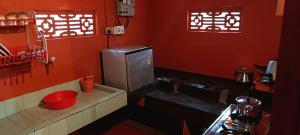 a small red kitchen with a sink and a toilet at Verdant Vagamon Farm House in Vagamon +43 photos