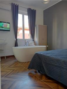 科里利亞諾卡拉布羅的住宿－FRABORGO，一间带浴缸的浴室和一张位于客房内的床