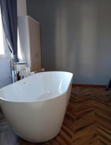 科里利亞諾卡拉布羅的住宿－FRABORGO，浴室铺有木地板,配有白色浴缸。