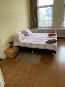 een slaapkamer met een bed en een houten vloer bij Sol y Mar in Vlissingen