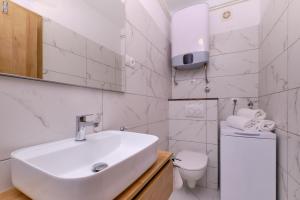 a white bathroom with a sink and a toilet at Sun in Mali Lošinj