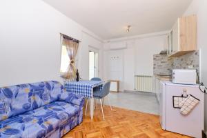 a living room with a blue couch and a kitchen at Sun in Mali Lošinj